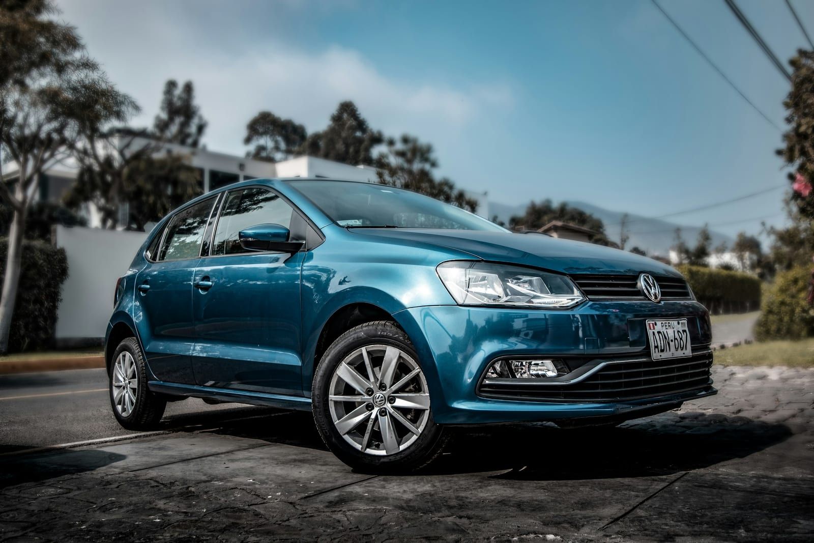 Metallic blue hatchback parked on a street